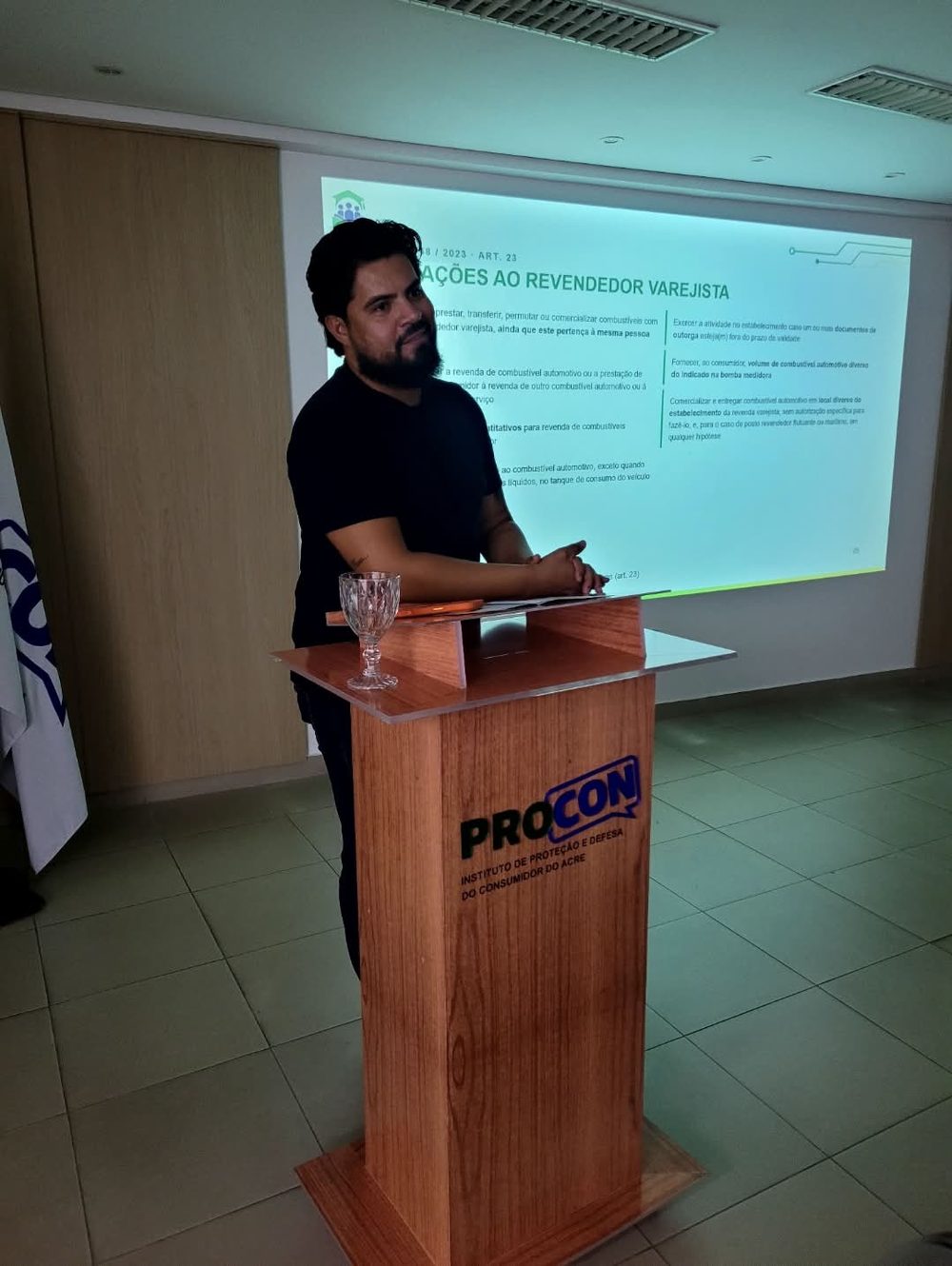 Palestrante no púlpito com a marca do Procon do Acre